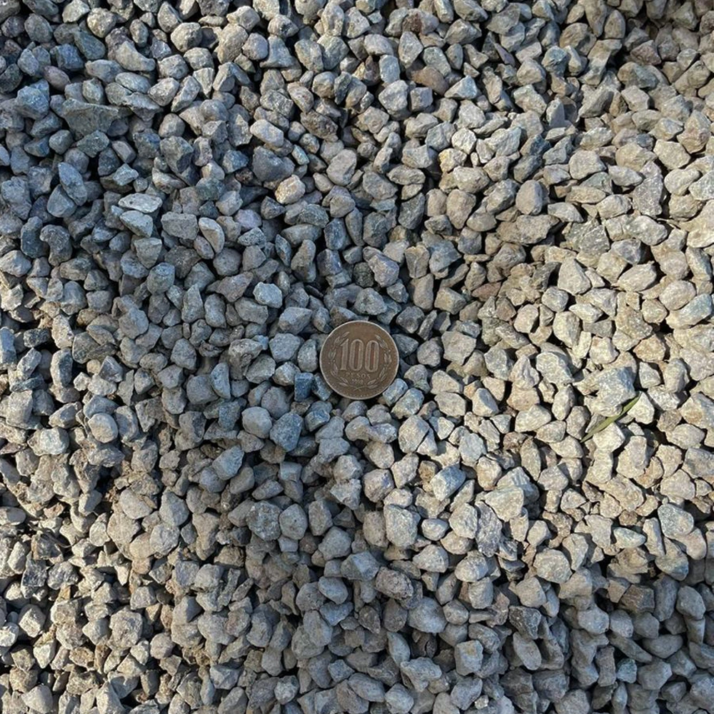 Montón de gravilla chancada 3/8” de color gris, con piedras pequeñas y angulares, ideal para construcción y drenajes.