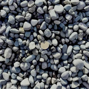 Montón de gravilla rodada 3/8” con piedras pequeñas, lisas y de tonos naturales, ideal para paisajismo y drenajes.