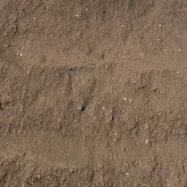 Montón de tierra vegetal oscura y fértil, con textura suelta y rica en materia orgánica, utilizada para jardinería y mejoramiento de suelos.